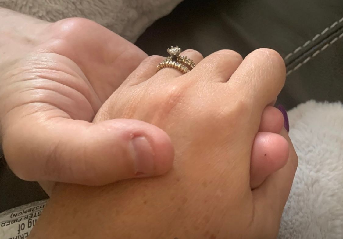 Two people holding hands in a gesture of support